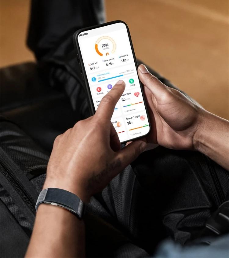 Una persona guarda l'app sul telefono, con Senses al polso